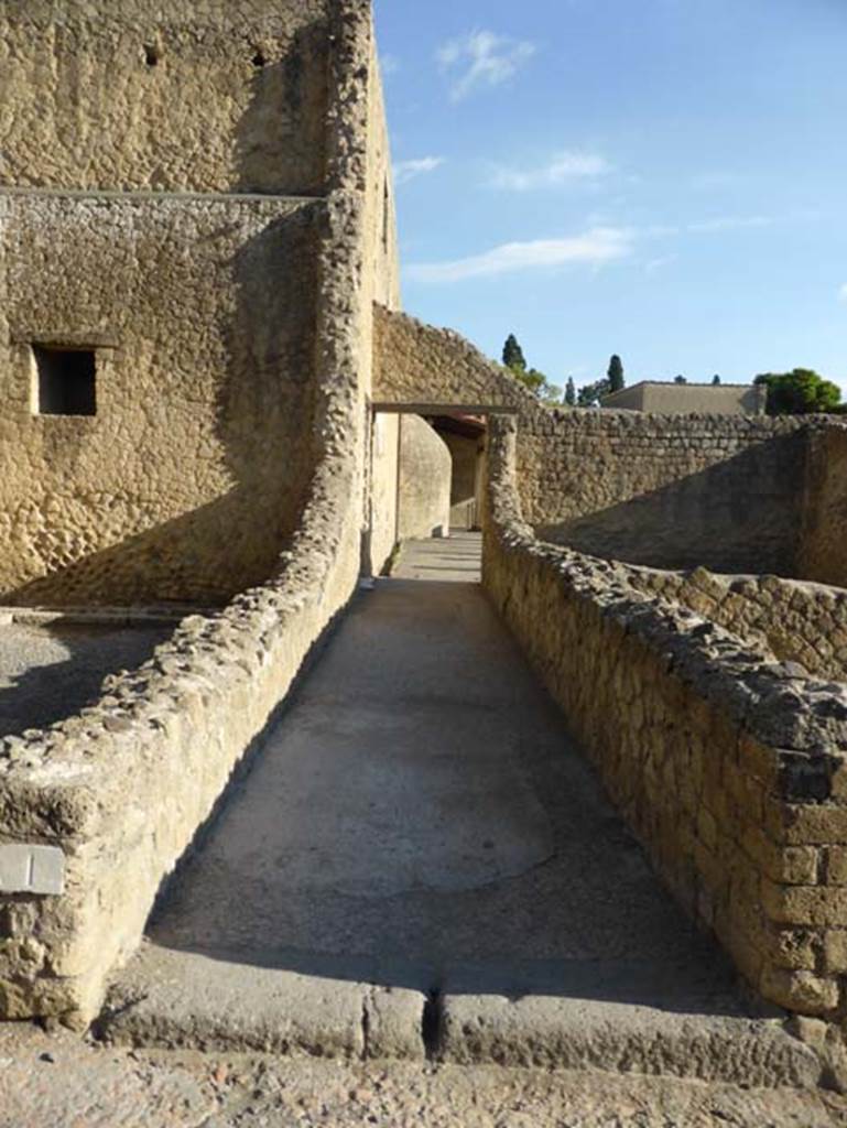 VI,1 Herculaneum, September 2015. Looking east through entrance doorway into corridor leading to the portico of the palaestra of the baths. On the left side of the doorway, at the end of the corridor, is the doorway into the dressing room (apodyterium). The white marble doorway threshold can be seen.